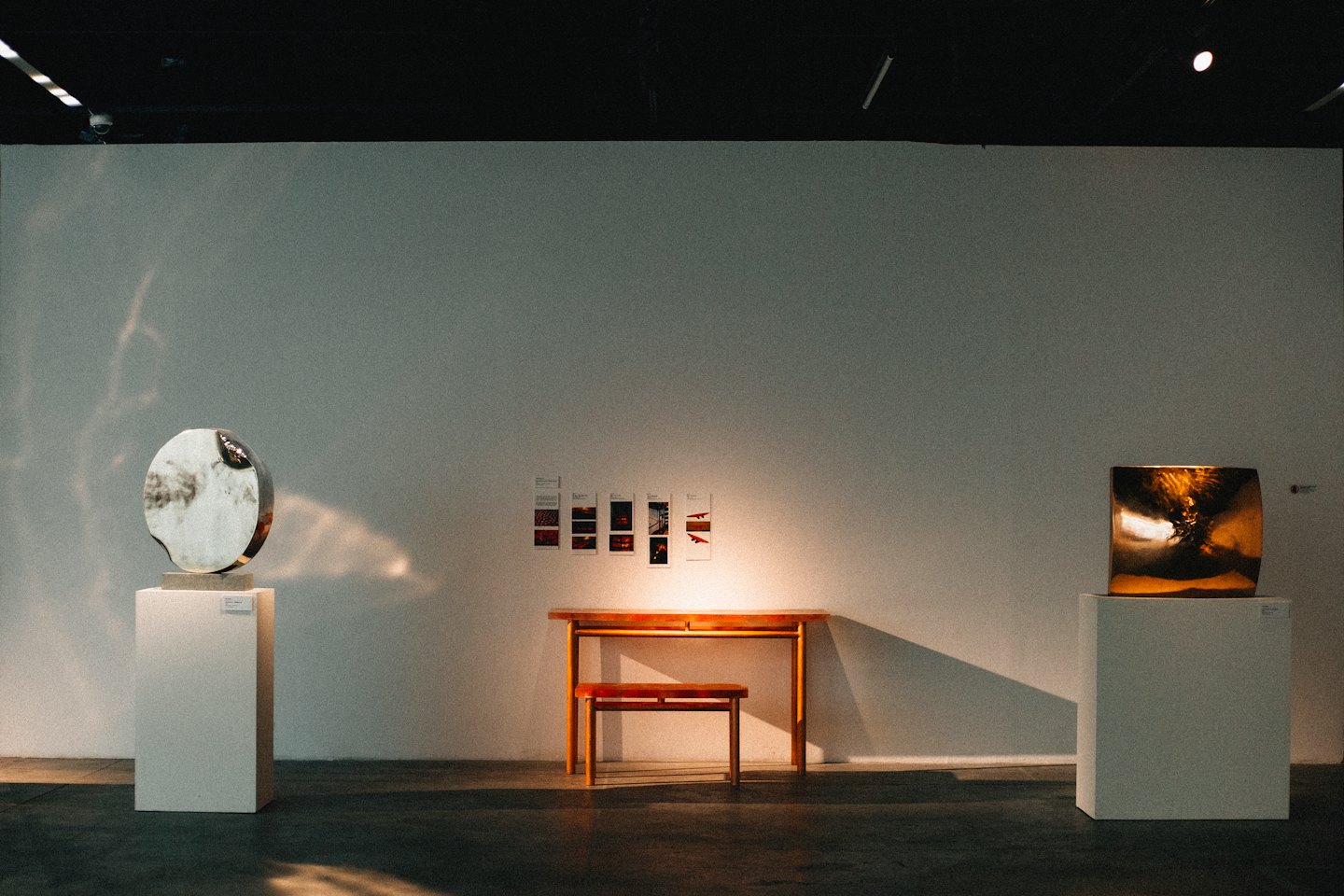 Twee abstracte sculpturen in een minimalistische kunstgalerie.